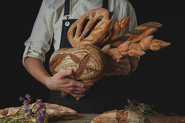 Image showing Variety of bread hold men\'s hands