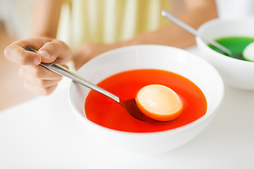 Image showing child coloring easter eggs by liquid dye at home