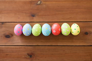 Image showing row of colored easter eggs on wooden table