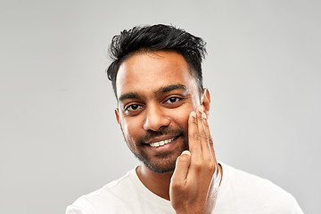 Image showing smiling indian man touching his beard