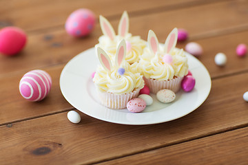 Image showing cupcakes with easter eggs and candies on table