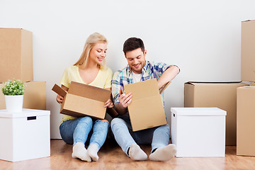 Image showing happy couple unpacking boxes at new home