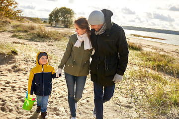 Image showing happy family walking along autumn beach