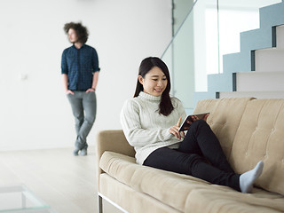 Image showing multiethnic couple at home using tablet computers