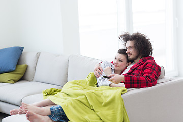 Image showing Young couple on the sofa watching television