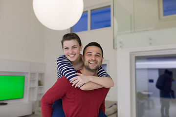 Image showing handsome man piggybacking his girlfriend