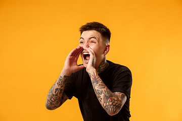 Image showing young casual man shouting at studio