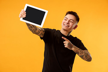 Image showing Portrait of a confident casual man showing blank screen of laptop