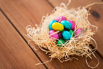 Image showing chocolate easter eggs in straw nest on table