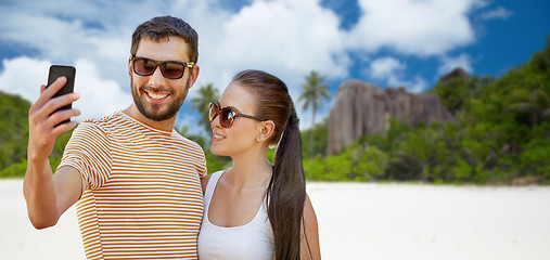 Image showing happy couple taking selfie by smartphone on beach