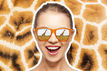 Image showing happy teen girl in sunglasses looking at giraffes