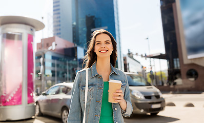 Image showing happy young woman drinking coffee on city street