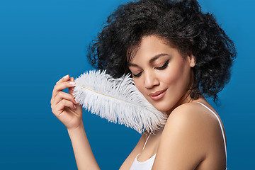 Image showing Beautiful mixed race woman holding white ostrich feather