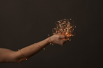 Image showing bright christmas lights in woman\'s hands