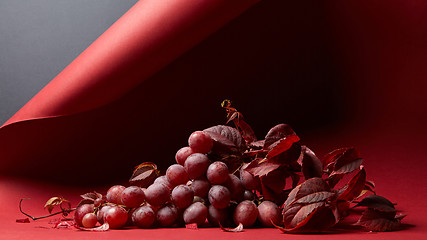 Image showing ripe fresh red grapes on a red background