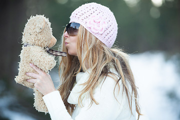 Image showing Girl blowing kisses to scruffy teddy bear