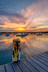 Image showing Beautiful sunset across the bay with moored yachts and boats