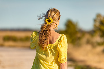 Image showing Woman outdoors in sunshine sunflower in her wavy hair