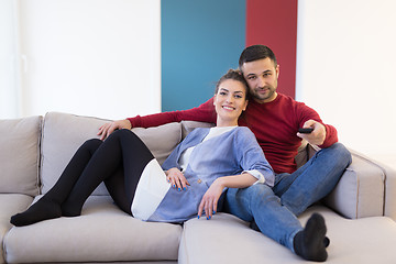 Image showing Young couple on the sofa watching television