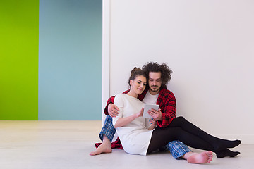 Image showing Young Couple using digital tablet on the floor