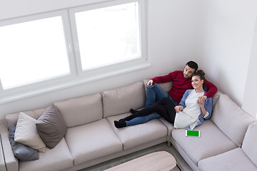 Image showing Young couple on the sofa watching television