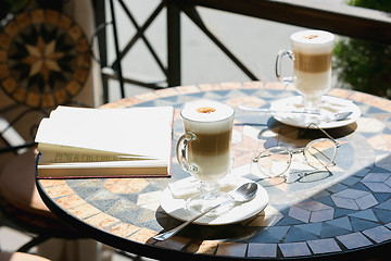 Image showing Cup of coffee with book on table in room
