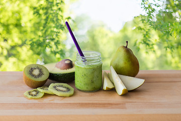 Image showing jar with fruit puree or baby food on wooden board