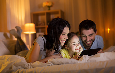 Image showing family with tablet pc in bed at night at home