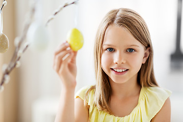 Image showing girl decorating willow by easter eggs at home