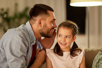 Image showing happy father whispering secret to daughter at home