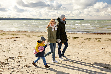 Image showing happy family going to picnic on beach in autumn