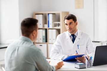 Image showing doctor with clipboard and male patient at hospital