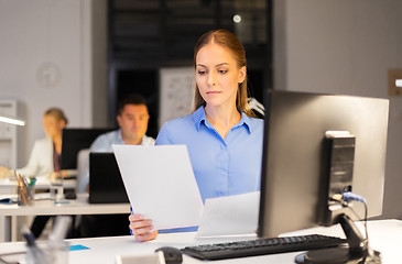 Image showing businesswoman with papers working at night office