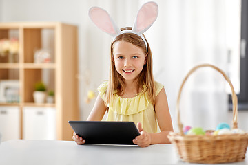 Image showing happy girl with tablet pc and easter eggs at home