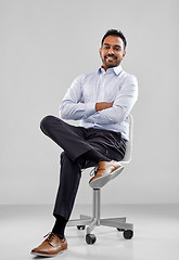 Image showing smiling indian businessman sitting on office chair