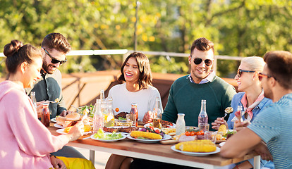 Image showing happy friends eating and drinking at rooftop party