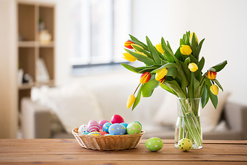 Image showing colored easter eggs in basket and flowers at home