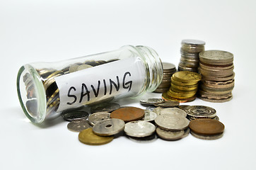 Image showing Saving lable in a glass jar with coins spilling out