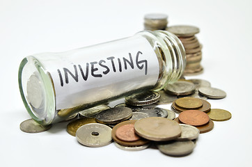 Image showing Investment lable in a glass jar with coins spilling out