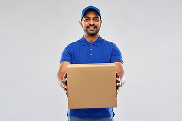 Image showing happy indian delivery man with parcel box in blue