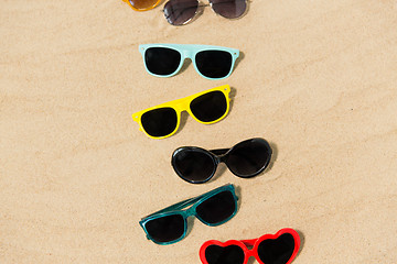 Image showing different sunglasses on beach sand