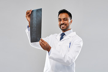 Image showing smiling indian doctor looking at spine x-ray