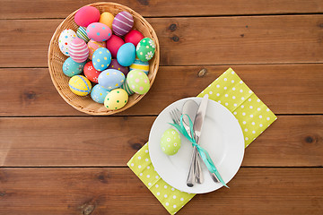 Image showing easter eggs in basket, plates, cutlery and flowers