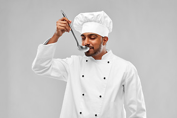 Image showing happy male indian chef tasting food from ladle