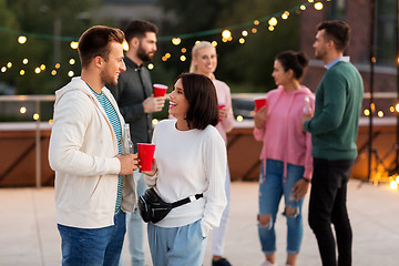 Image showing friends with drinks in party cups at rooftop