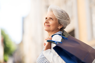 Image showing senior woman with shopping bags in city