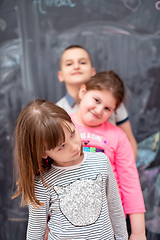 Image showing group of kids standing in front of chalkboard