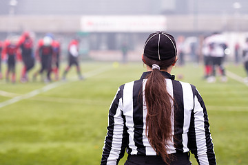 Image showing rear view of female american football referee