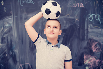 Image showing happy boy holding a soccer ball on his head