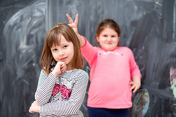 Image showing little girls having fun in front of chalkboard